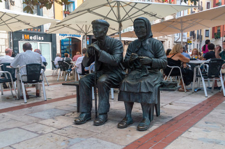 Burgos, Spain - August 22, 2023: Seated elderly couple sculpture.のeditorial素材