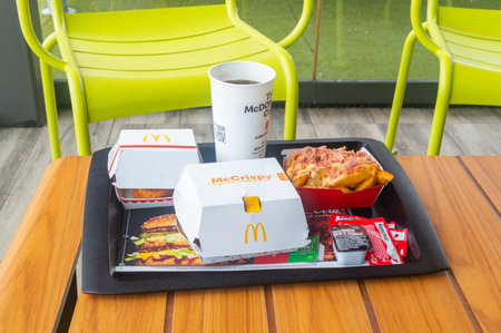 Aranda de Duero, Spain - September 16, 2023: McDonald's menu with McCrispy BBQ with bacon, Top Fries with bacon and cheese deluxe, McNuggets and Coca-Cola for drink.のeditorial素材