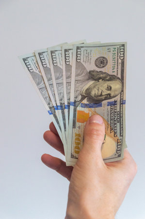 5 one hundred US dollars held in his right hand.の写真素材