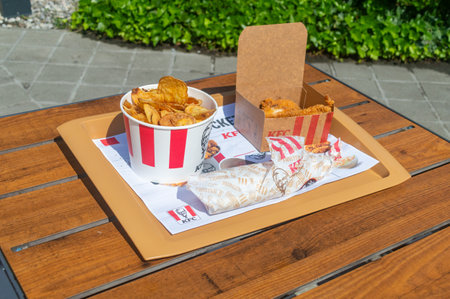 Ansfelden, Austria - June 2, 2024: KFC menu with Diavola Twister, 5 hot wings and chips buckets.のeditorial素材