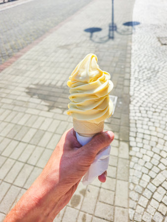 Ice cream cone in man's hand.の写真素材