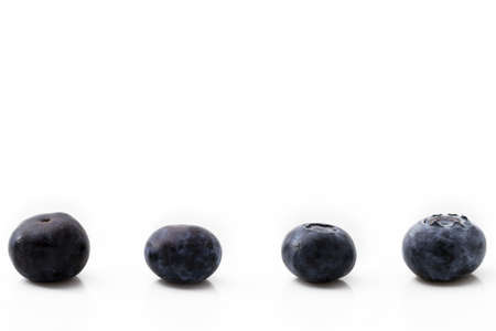 four blueberries in a row isolated on white backgroundの写真素材