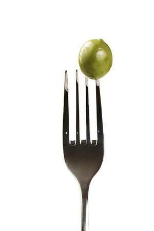 one green olive on a fork isolated on white backgroundの写真素材
