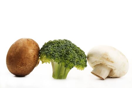 one brown mushroom one broccoli and a white mushroom on white backgroundの写真素材