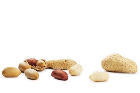 some cracked and closed peanuts on white background