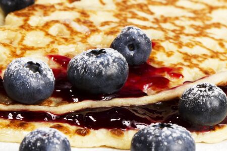 closeup of sugar covered blueberries with jam on pancakesの写真素材