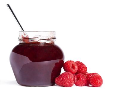  raspberry jam jar with a spoon and raspberries aside on white background