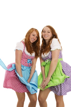 two bavarian dressed girls fighting with wind on white backgroundの写真素材