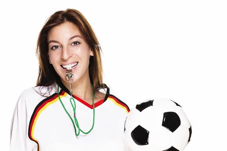 beautiful woman with a whistle holding football on white backgroundの写真素材