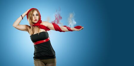 beautiful woman with red scarf in front of a blue background and a smoking armの写真素材