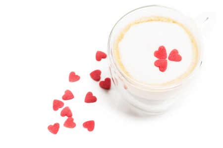 sugar hearts on and aside a espresso with milk foam on white backgroundの写真素材