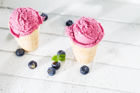 blueberry ice cream from top with blueberries aside on white wood
