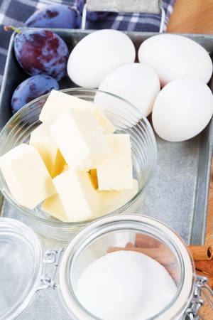butter in a small glass bowl between baking ingredients on a metal trayの写真素材