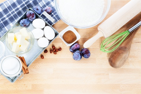 baking ingredients from top for a plum cake on wooden backgroundの写真素材