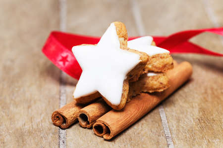 cinnamon star on cinnamon sticks with a red ribbon on wooden backgroundの写真素材