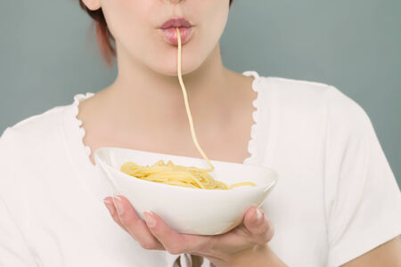 mouth closeup of a woman sucking spaghettiの写真素材