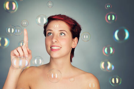 beautiful young woman playing with soap bubblesの写真素材