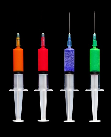 A set of 4 glowing syringes isolated on black..の写真素材