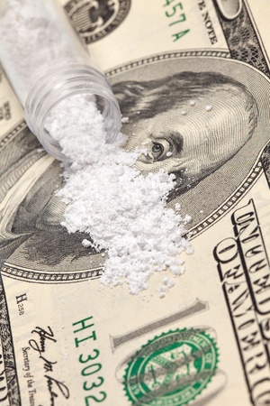 An obscured 100 dollar bill with a pile of white powder covering it の写真素材