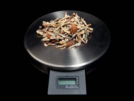 A small scale with a pile of magic mushrooms on it.