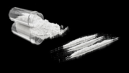 Three lines of cocaine beside a vial of powder の写真素材