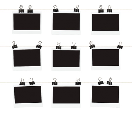 Three rows of three blank pieces of instant film hanging from binder clips on strings isolated on...
