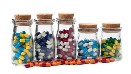 Five jars of various pills isolated on a white background.
