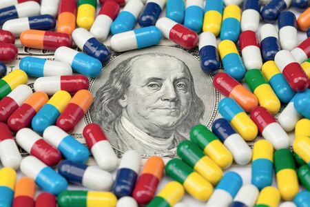 Closeup of Benjamin Franklin's bust on a US one hundred dollar note covered with pills.の写真素材