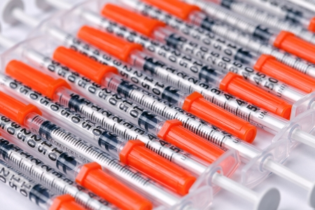 A row of medical syringes on a white background.の写真素材