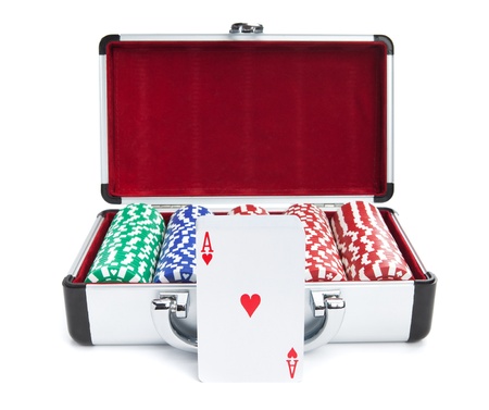 A deck of cards in front of a case containing stacks of poker chips isolated on white.の写真素材