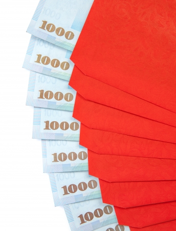 A fan of red envelope with 1000 New Taiwan dollar notes in each of them isolated on a white background.の写真素材