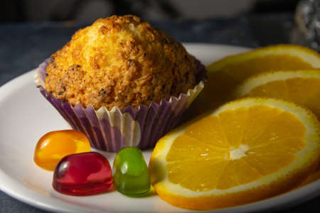 Tasty looking colorful dessert with oranges, muffins and sweets. Side view close up.High quality photoの写真素材
