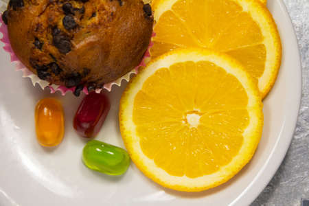 Tasty looking colorful dessert with oranges, muffins and sweets. Top view close up. High quality photoの写真素材