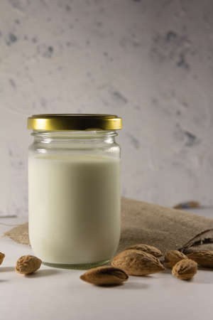 Almond milk in the glass with with almond nuts in a shell. High quality photoの写真素材