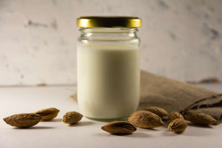Almond milk in the glass with with almond nuts in a shell. High quality photoの写真素材