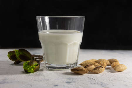 Almond milk in the glass with with almond nuts in a shell. High quality photoの写真素材