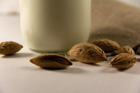 Almond milk in the glass with with almond nuts in a shell. High quality photoの写真素材