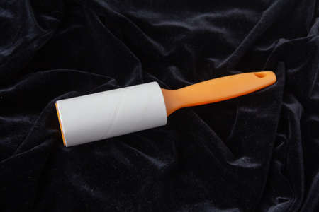 Sticky cleaner from wool and dust for clothes on black dusty velvet. High quality photoの写真素材