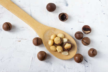Wooden spoon on white background and macadamia nuts, superfood. High quality photoの写真素材