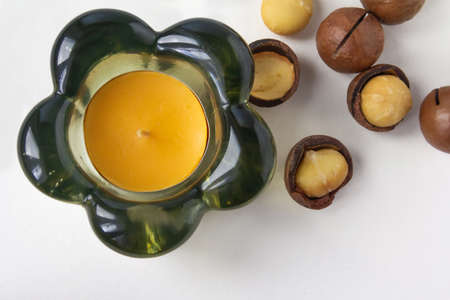 Decorative glass candlestick and macadamia nuts on white background. High quality photoの写真素材