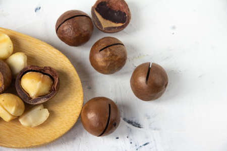 Wooden spoon on white background and macadamia nuts, superfood. High quality photoの写真素材