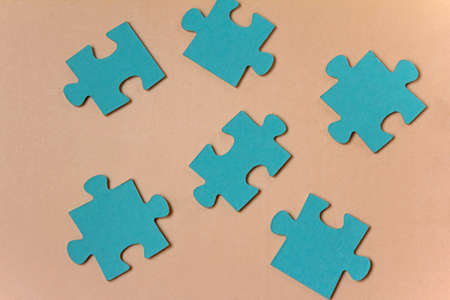 Concept foto with blue puzzle pieces on beige background. High quality photoの写真素材