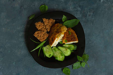 Fried chicken with herbs and cucumbers on a dark background. Top view. High quality photoの写真素材