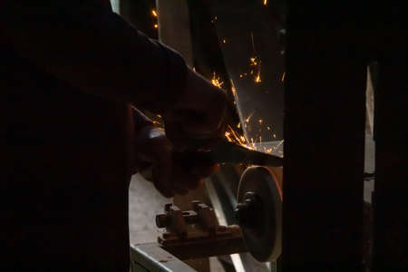 Dark foto with hands grinder and sparks. High quality photo