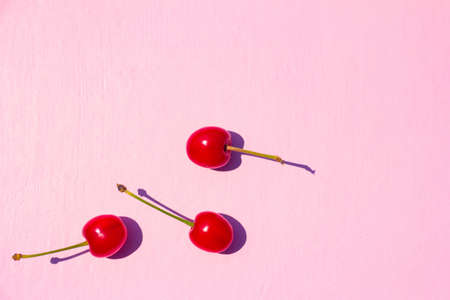 Ripe red sweet cherries on pastel pink background. High quality photo