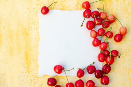 Blank paper card mockup with red cherries on yellow background. High quality photoの写真素材