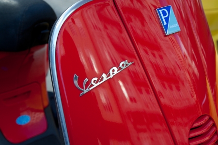VALENCIA, SPAIN - JANUARY 28, 2014: Close up detail of Vespa scooter logo parked in the street of...