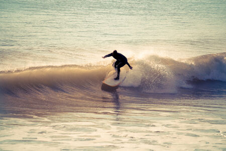 Surfing in the early morning with retro effect applied.