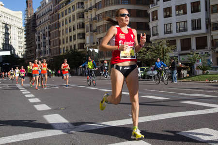 VALENCIA, SPAIN - NOVEMBER 16, 2014: Woman runner Bea Molina of Spain competes in the 2014 Valencia Marathon.  Molina was the first Spanish woman to cross the finish line with a time of 2:52:38.のeditorial素材