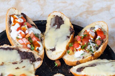 Molletes. Vegetarian Mexican food similar to bruschetta. Refried beans and melted cheese on toasted bread.の写真素材